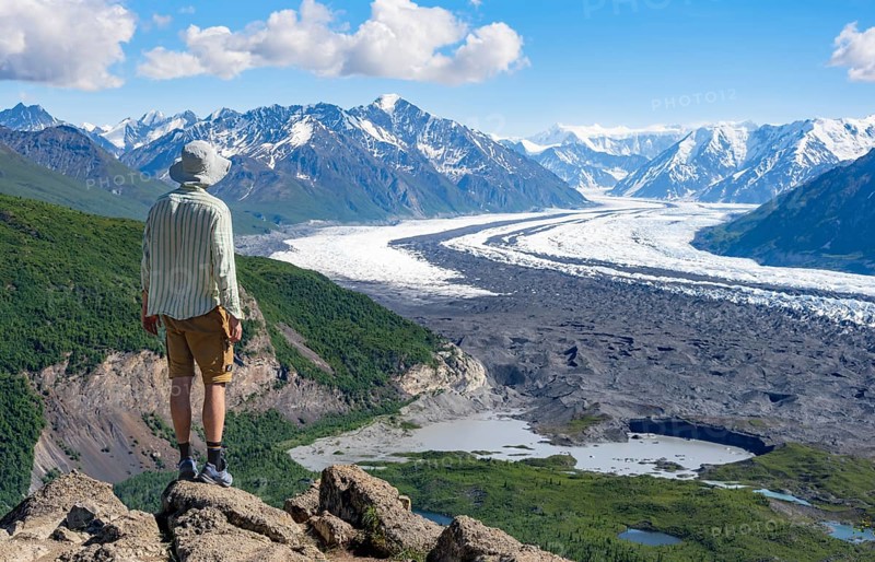 Young man enjoying the view, view of impressive mountain landscape with Matanuska glacier and glaciated mountain peaks, Lion's Head, Chugach Mountains, Alaska, USA