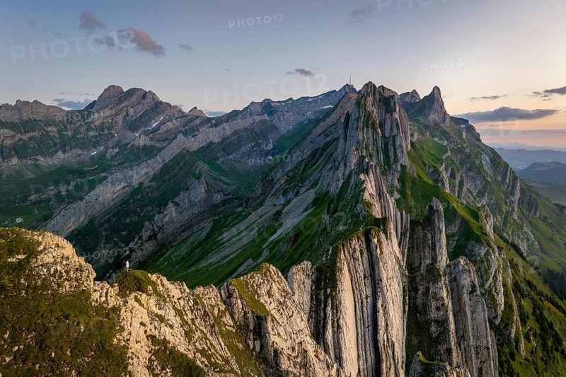 A breathtaking panoramic view of the Altenalp Turm in Switzerland during sunset. The rugged peaks and lush green valleys create a stunning landscape, perfect for nature lovers