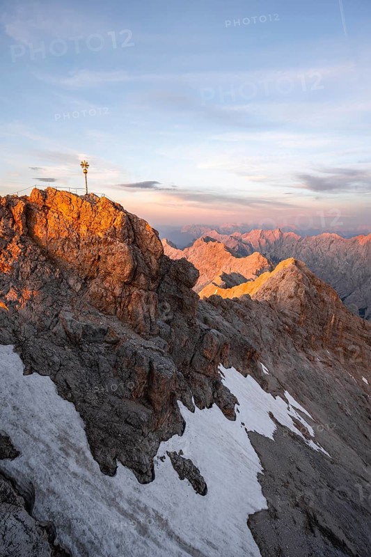 Summit of the Zugspitze with golden summit cross, alpenglow at sunset, Northern Limestone Alps, Wetterstein Mountains, Bavaria, Germany