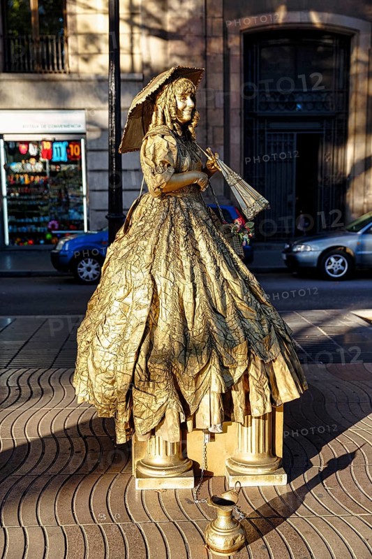 Street performer, mime, living statue of a golden lady with parasol, city centre, Barcelona, Spain