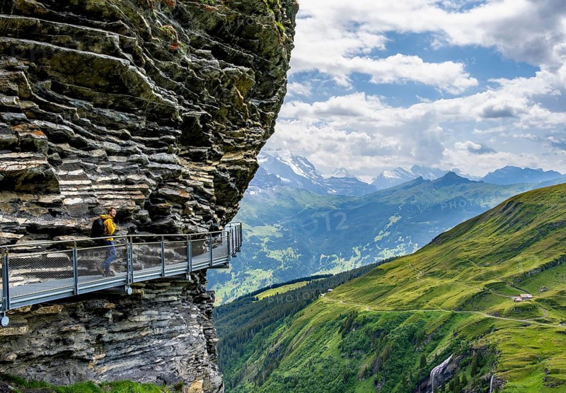Young man on First Cliff Walk, metal trail on a rocky outcrop, Grindelwald First, in front of impressive mountain scenery, Bernese Alps, Bernese Oberland, Switzerland