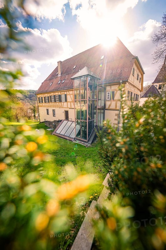 A traditional house with a modern glass façade, surrounded by a sunny garden and cloudy sky, Deufringen, Aidlingen, Böblingen district, Germany