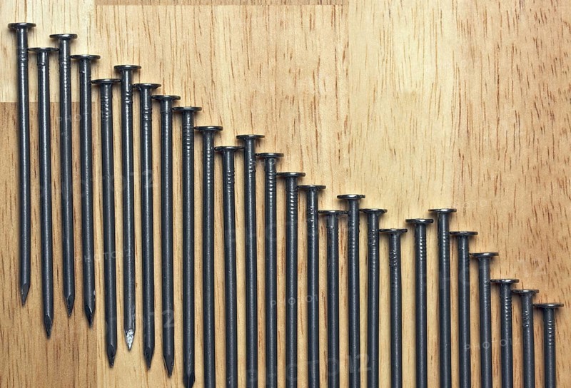 Declining Graph of Nails on a Wood Background