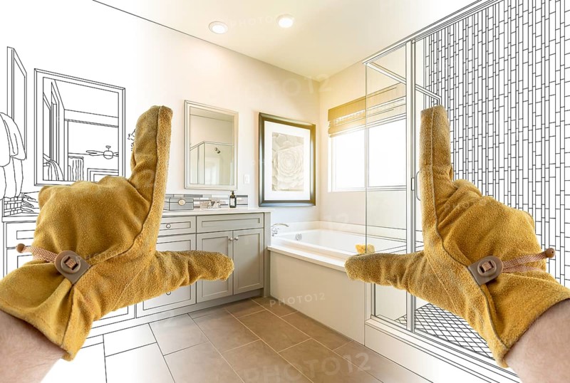 Male Contractor Hands Framing Completed Section of Bathroom Over Bathroom Drawing