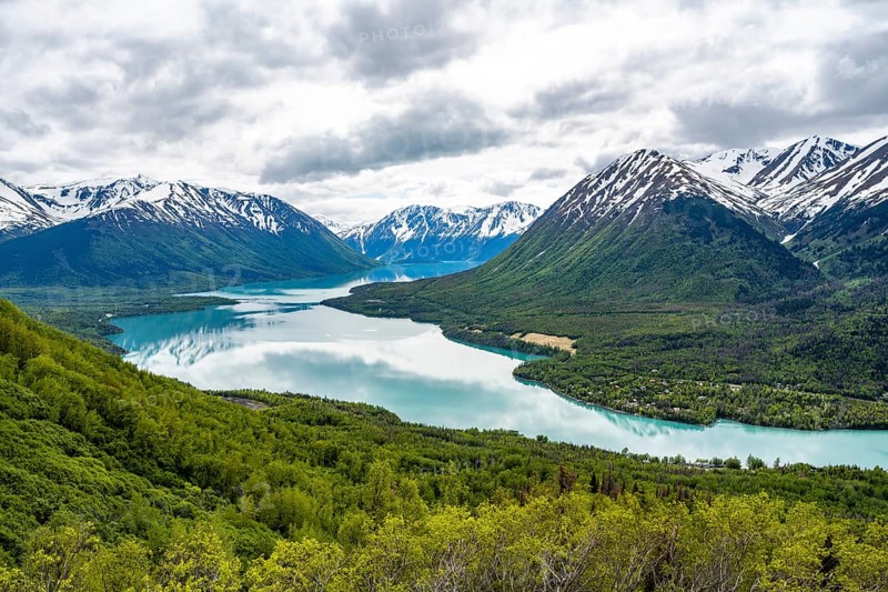View of snowy mountains in spring and turquoise blue Kenai Lake, Slaughter Ridge Trail, Cooper Landing, Kenai Peninsula, Alaska, USA