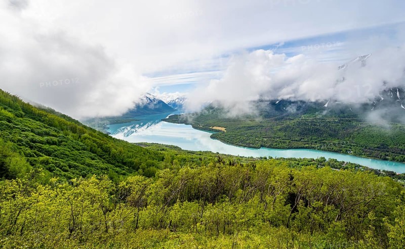 View of snowy mountains in spring and turquoise blue Kenai Lake, Slaughter Ridge Trail, Cooper Landing, Kenai Peninsula, Alaska, USA