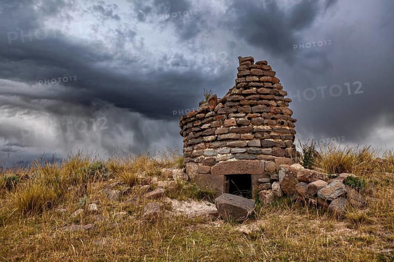 Abandoned stone ruin against dramatically cloudy sky, The Chullpas of Sillustani near Puno in Peru