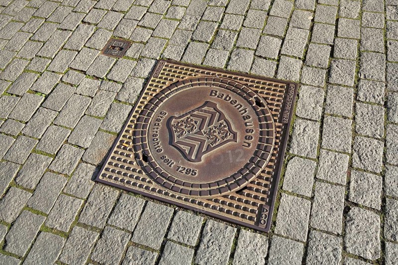 Square manhole cover with city coat of arms and date for historical city rights, paving stones, inscription, Babenhausen, Hesse, Germany
