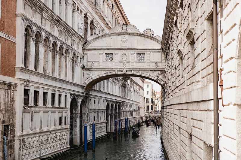 Stunning architecture of Venice, Italy, as captured in this image of an iconic stone bridge over a tranquil canal, showcasing intricate details and classic design