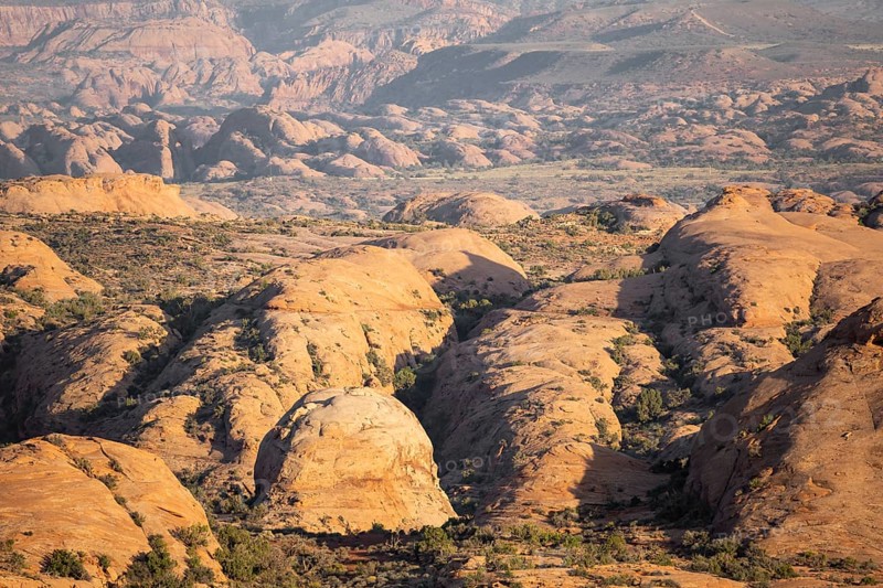 Breathtaking aerial view of Arches national park desert landscape, showcasing unique rock formations and vibrant colors under the golden sunlight, highlighting nature's artistry