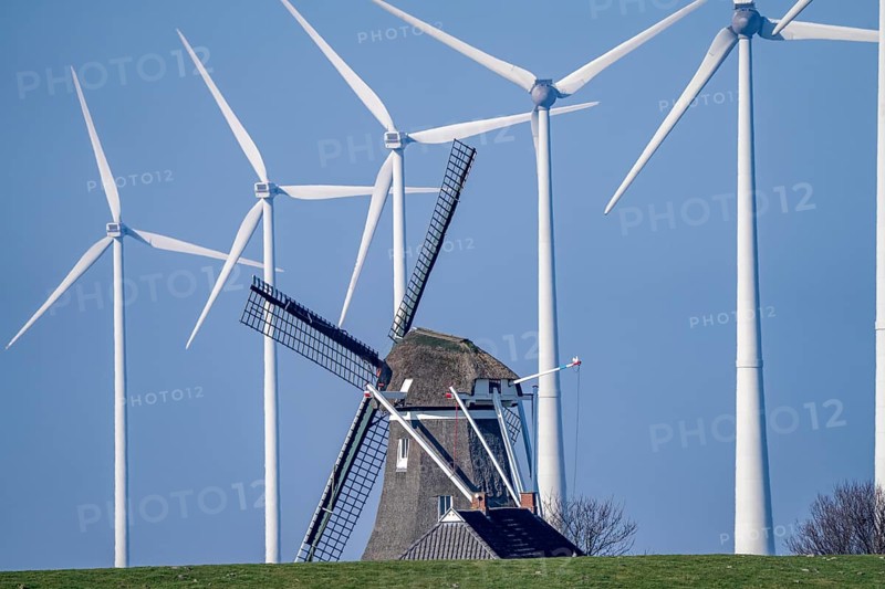 Poldermolen De Goliath windmill stands between the high-tech wind turbines in Eemshaven, historic windmill from around 1882, rebuilt and rebuilt several times, Westereems wind farm, Groningen province, Netherlands