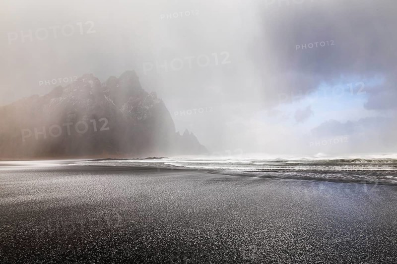 Sleet on black lava sandy beach against mountain backdrop, sea, winter, Stokksnes, Vestrahorn, Klifatindur, Höfn, Iceland, Scandinavia