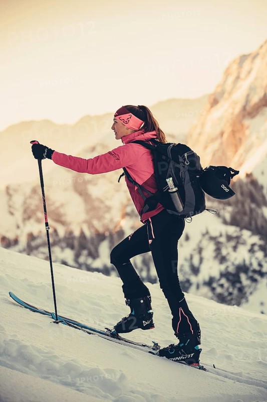 A woman's ski tour at sunrise on the Tegelberg in the Allgäu in the Ammergebirge, Bavaria, Germany