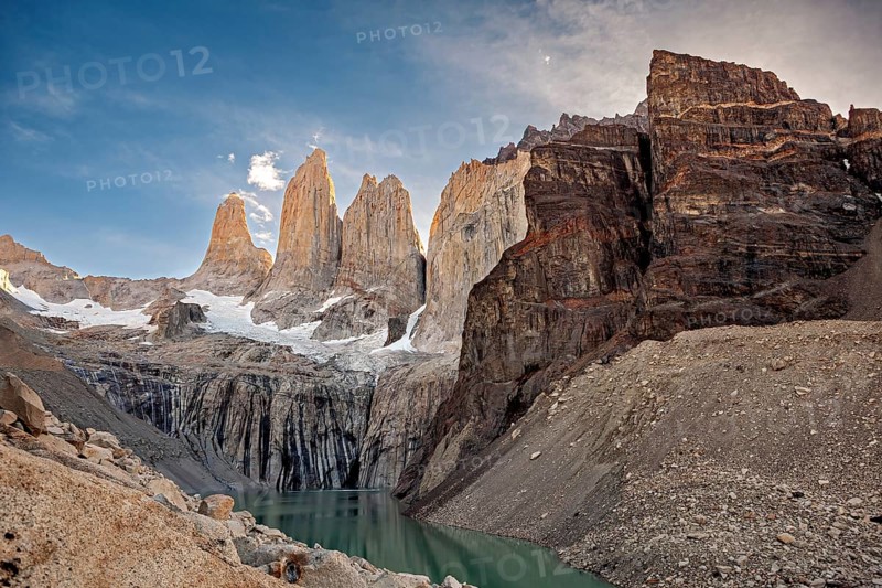Rocky ridges and snow above a lake in a remote valley, The rock towers of Torres del Paine in Patagonia Chile