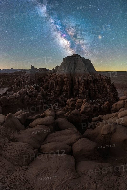 A stunning view of the Milky Way arching over the intriguing rock formations of Goblin Valley State Park, Utah, highlighting desert beauty under a starlit sky