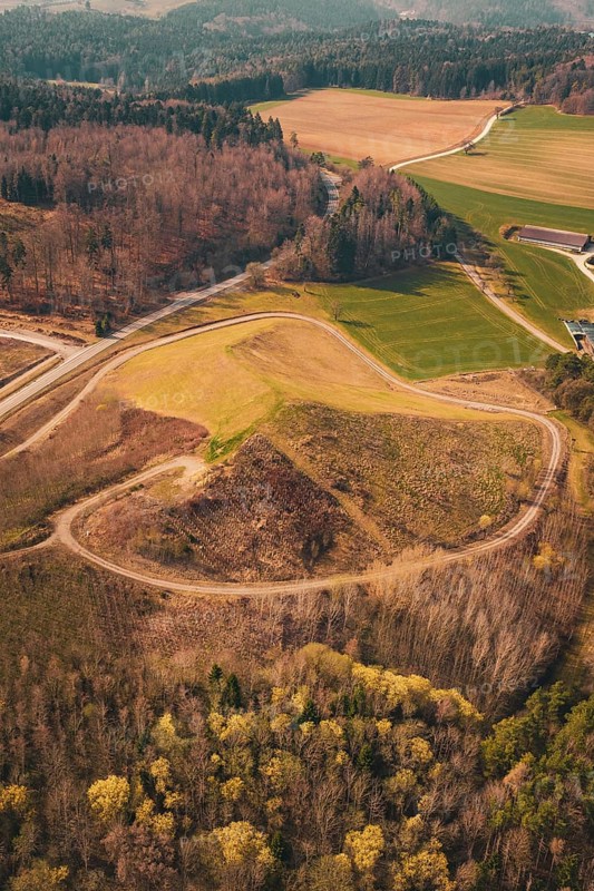 Winding roads through hilly landscape with meadows and forests with a clear view from above, old deposit in front of PV Bau, Lindenrain, Calw, Germany