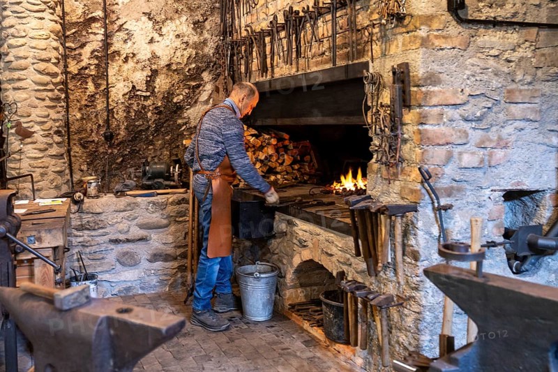 An elderly blacksmith in Austria's Salzburg region preserves the centuries-old art of blacksmithing in his rustic workshop, surrounded by stone walls and a glowing forge