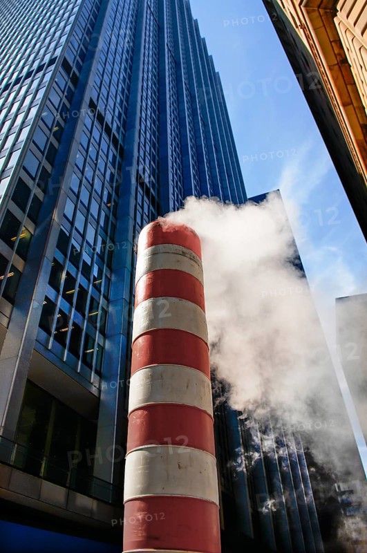 Steaming chimney at a construction site behind a skyscraper, New York City, USA
