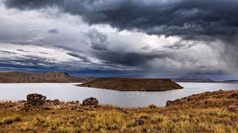 A lake with an island in cloudy sky, atmospheric landscape, The Chullpas of Sillustani near Puno in Peru