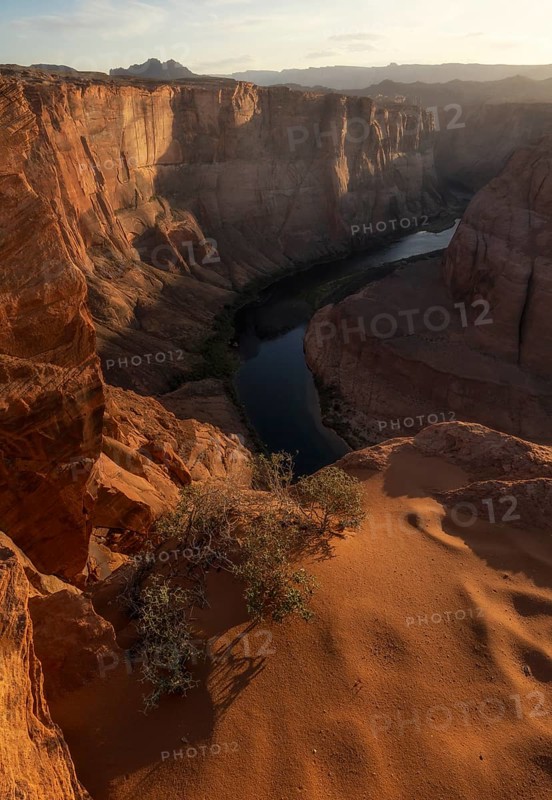 Golden light envelops Horseshoe Bend, highlighting the majestic curves of the canyon and the tranquil flow of the Colorado River below, creating a breathtaking natural masterpiece