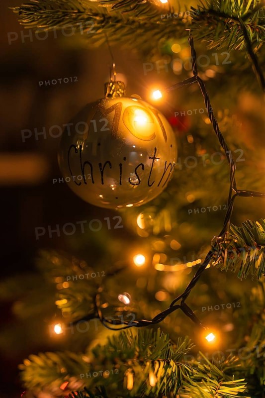 Close-up of a golden Christmas tree ball surrounded by warm lights of a Christmas tree, Christmas market Nagold, Black Forest, Germany