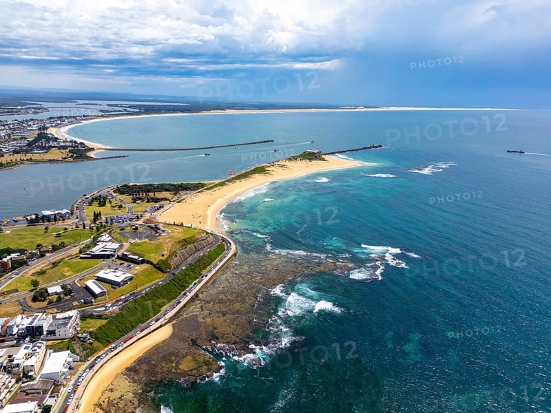 Aerial view of Beach in New South Wales, Australia, showcasing the stunning coastline with sandy beaches, blue waters, and lush greenery under a partly cloudy sky