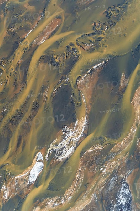 Aerial photograph showcasing Iceland's stunning river patterns. The natural textures and colors create a mesmerizing abstract landscape, perfect for backgrounds or artistic projects