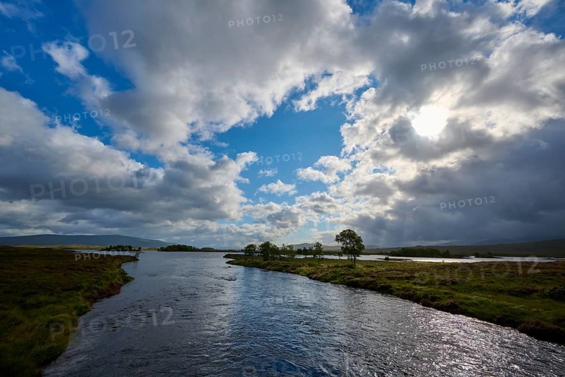 A river over which the sun shines in a partly cloudy sky and creates a calm atmosphere, Rannoch Moor, Bridge of Orchy, Scotland, United Kingdom, Great Britain