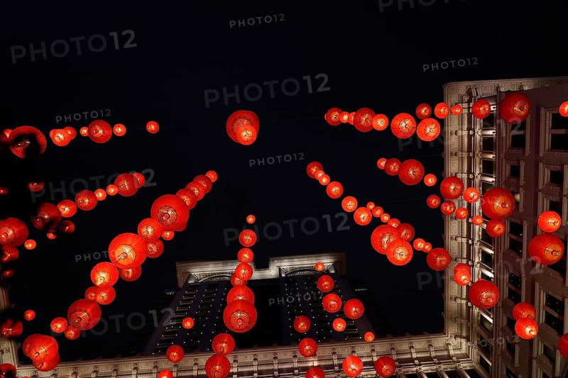 From below a festive red lanterns adorn a classical building in Hong Kong, brilliantly lit against the night sky to celebrate Chinese New Year, showcasing traditional decorations in an urban setting
