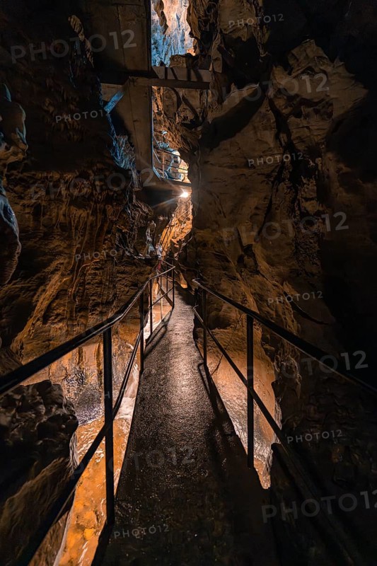 Narrow path through a cave, illuminated, surrounded by rocks and an adventurous atmosphere, Beatus Caves, Switzerland
