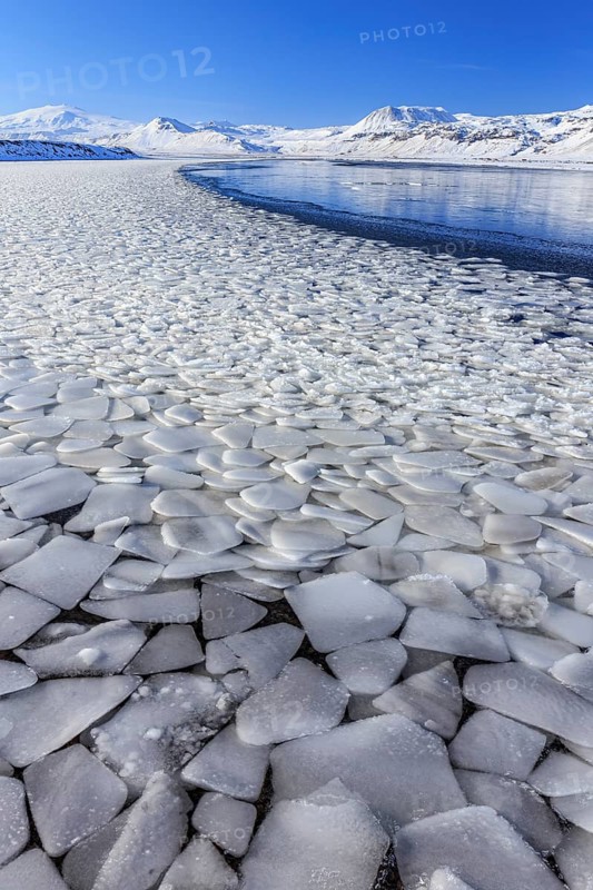 Ice floes on a lake in front of snow-covered mountains, sun, snow, winter, Snaefellsnes, Vesturland, Iceland