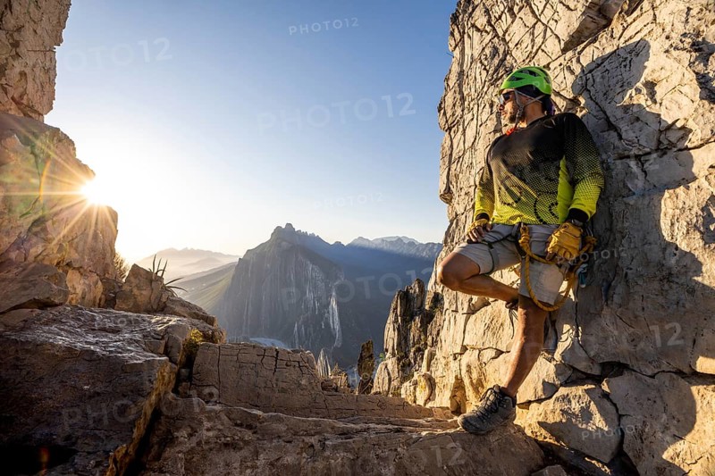 A mountaineer takes a break while practicing climbing and rappelling at Eagleâ€™s Nest in Monterrey, Mexico. The scenic rock face and clear blue sky create a stunning outdoor setting
