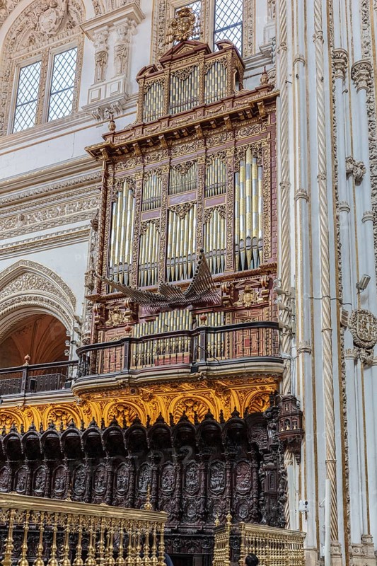 Large baroque church organ with detailed woodwork and golden accents in a cathedral, Cordoba