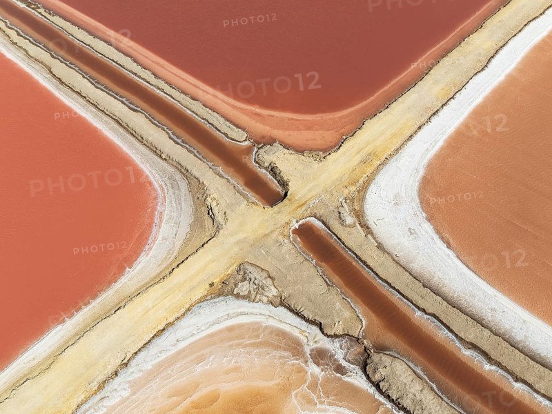 Saline ponds at the Bonanza salt works near Sanlúcar de Barrameda. The reddish colour depends on the level of salinity and is directly caused by the algae Dunaliella salina and brine shrimp. Aerial view. Drone shot. Cádiz province, Andalusia, Spain