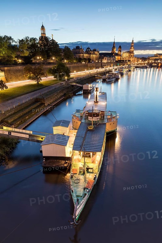 Paddle steamer of the Sächsische Dampfschifffahrt on the Terrassenufer, city view with Elbe in the evening, illuminated silhouette at the blue hour, Dresden, Saxony, Germany
