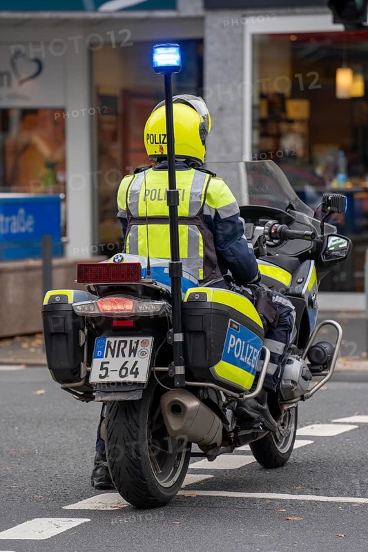 Police officer with motorbike blocks off a street during a demonstration in Düsseldorf, North Rhine-Westphalia, Germany