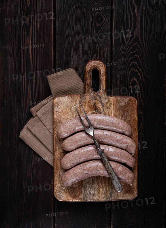 Raw sausages in English with bacon, for grilling, on a cutting board, top view, no people
