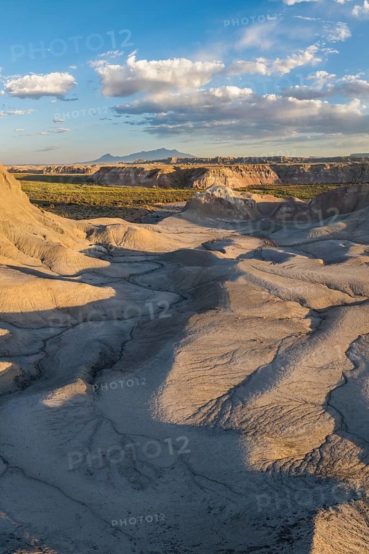 Stunning aerial shot capturing the unique bentonite hills of Utah, showcasing their intricate textures and vast, arid expanse under a clear blue sky