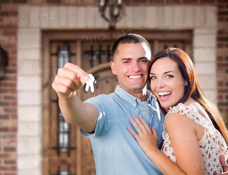 Young Military Couple In Front of Front Door of New House Holding Keys
