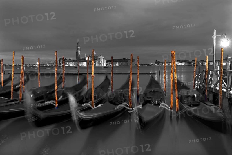 Nocturnal atmosphere with moving gondolas, San Georgio Maggiore in the back, Guidecca island on the right, black and white, Venice, Italy