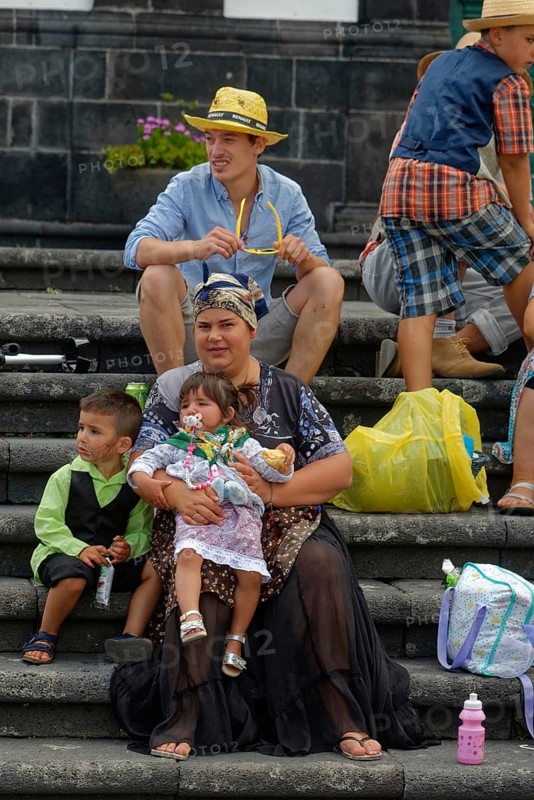 Mother in traditional dress holding two children on a staircase, Fenais da Luz, Sao Miguel Island, Azores, Portugal