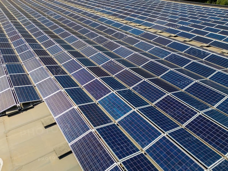 An aerial view of a solar panel array in Switzerland, showcasing the efficient use of renewable energy within a picturesque landscape of the Swiss region