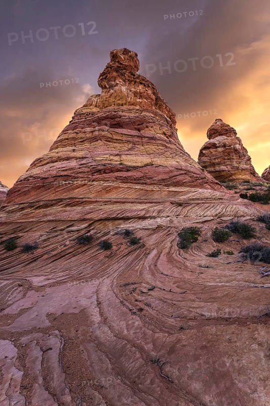 Majestic sandstone formations tower under a radiant sunset sky in Coyote Buttes, located in the Paria Canyon-Vermilion Cliffs Wilderness, Arizona, USA
