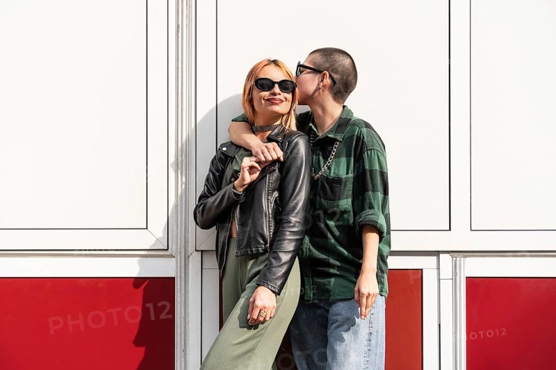 A Colombian lesbian couple shares a tender moment outdoors, symbolizing love, freedom, and equal rights. Their casual attire reflects a relaxed, joyful atmosphere