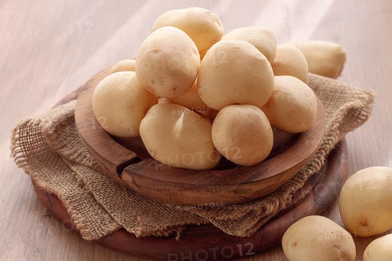 Boiled new potatoes, in a wooden bowl, on a rustic table, natural light, no people