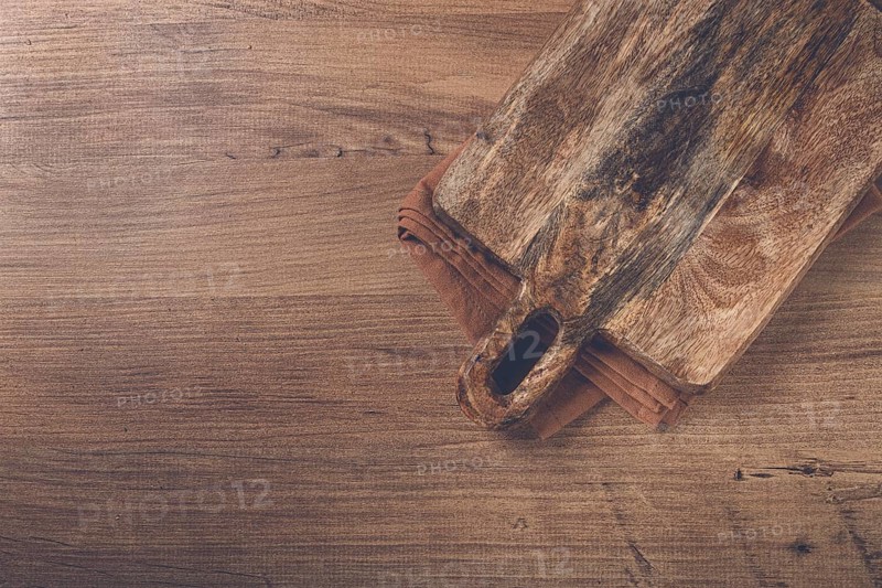 Square, chopping wooden board, chopping board with handle, on a kitchen towel, rustic style, top view, no people