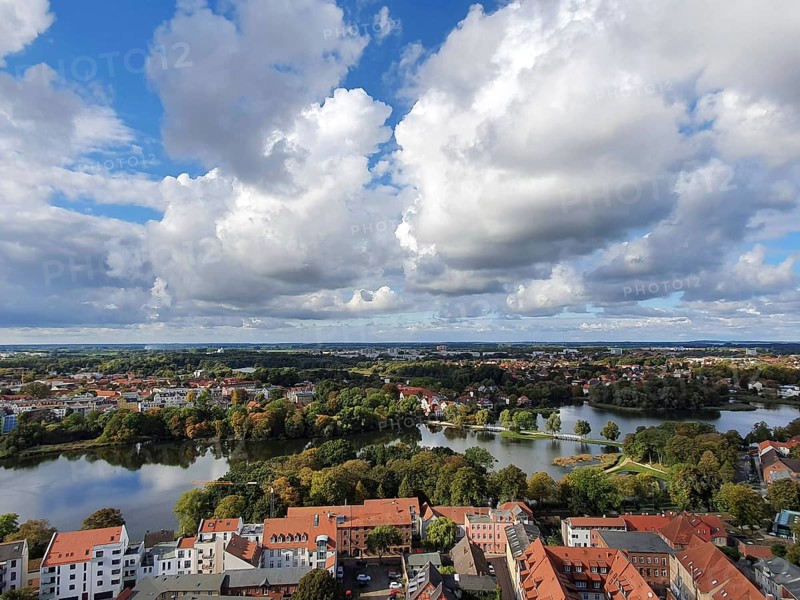 View from above of Szczecin city view with red roofs and a lake in the foreground, surrounded by greenery