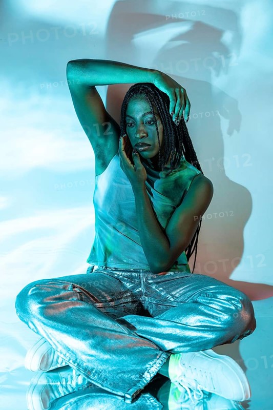 A futuristic image of a young African woman exploring the metaverse, dressed in stylish attire. The setting is illuminated with a digital, ethereal glow reflecting innovation