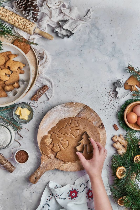 Top view of an anonymous woman preparing desserts for christmas at a table with christmas decorations