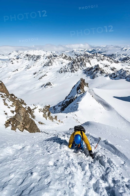 Mountaineer with ice axe and crampons, ascent through steep snowfield to Piz Kesch or Piz d'Es-cha in winter, view of mountain panorama with Vadret da Porchabella glacier, Albula Alps, Rhaetian Alps, Grisons, Eastern Switzerland, Switzerland